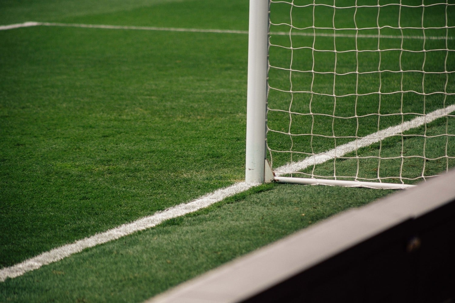 Goal post and net on a green artificial 3G football pitch.